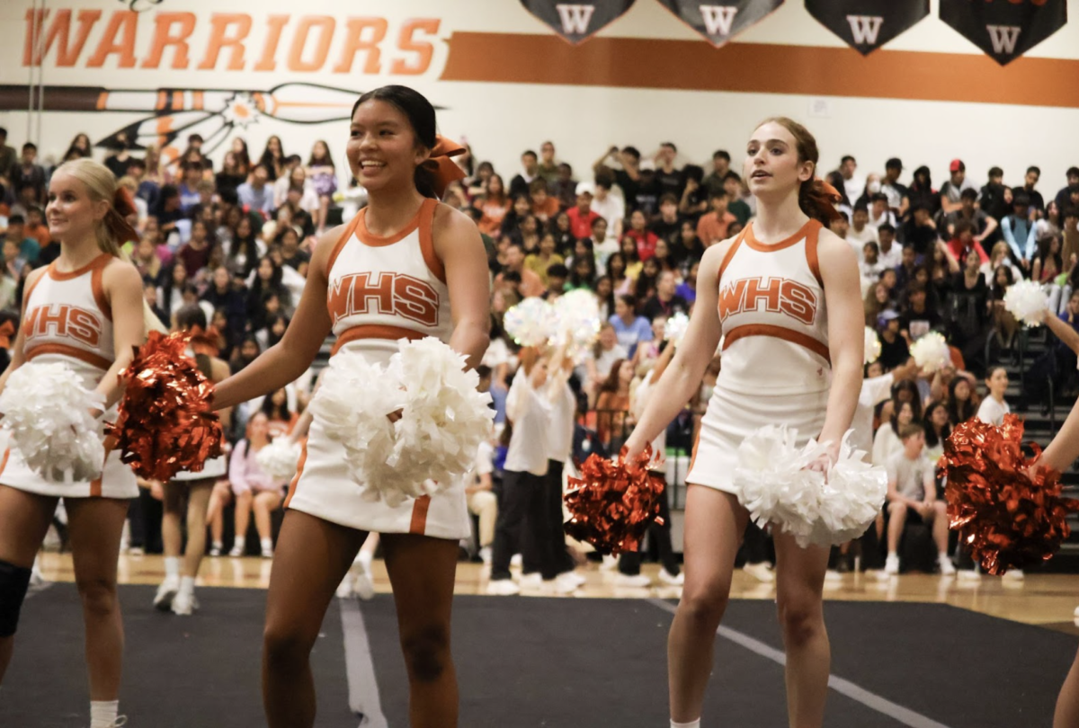 Hyping up the crowd before the beginning of the pep rally, cheerleaders Lauren Patterson '26, Aliyu Yu '27, and Leah Kleinman '25 move in a synchronized combo. The varsity cheer team was later spotlighted in the pep rally during their performance to Chappell Roan's "Hot to Go."